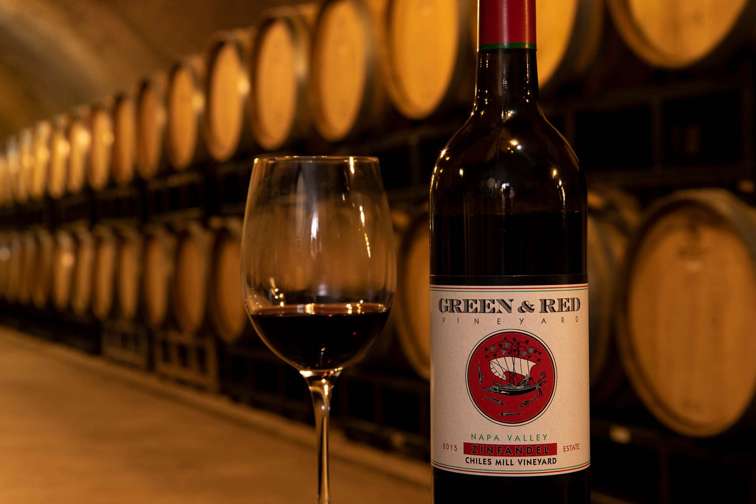 A bottle of Green and Red Zinfandel on a barrel in the cellar